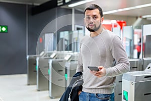 Portrait of man passing faregate on subway station