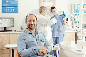 Portrait of man patient sitting on dental chair preparing for stomatology consultation