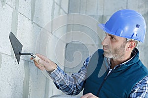 portrait man plastering concrete wall