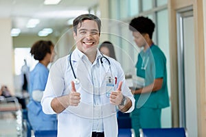 Portrait of man professor doctor hanging stethoscope thumbs up posing have group students on background in classroom hospital