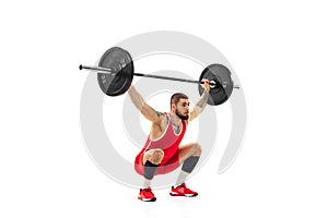 Portrait of man in red sportswear exercising with a weight isolated on white background. Sport, weightlifting, power