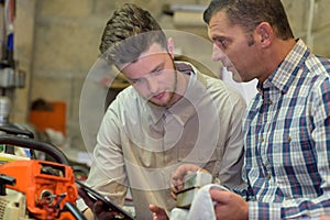 Portrait man repairing lawn mower engine