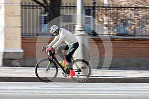 Portrait of man riding bicycle, professional cyclist training on city streets. Concept of people endurance and motivation