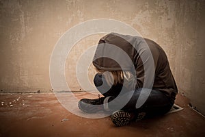 Portrait of man sad, drug addict man sitting on the floor in corner