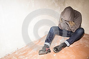 Portrait of man sad, drug addict man sitting on the floor in corner