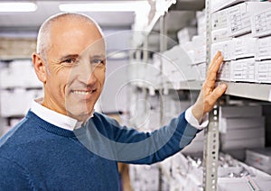 Portrait, man and search by shelves in distribution warehouse and happy in career with inspection of stock. Smile face