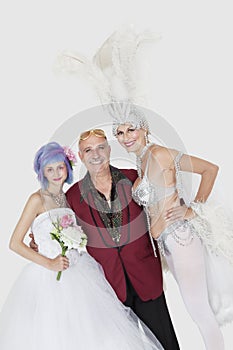 Portrait of man with senior showgirl and daughter in wedding dress over gray background