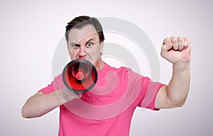 Portrait of man shouting with a red megaphone and raised fist