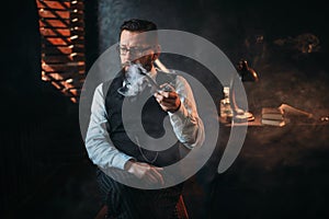 Portrait of man sitting on chair and smoking pipe