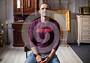 Portrait of man sitting at home in modern interiour