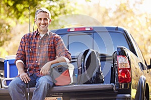 Portrait Of Man Sitting In Pick Up Truck On Camping Holiday