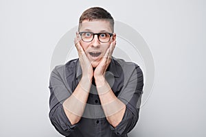 Portrait man smiling joyfully touching happy shocked face isolated on white studio background