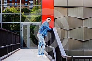 Portrait of a man in a sports suit, a jean jacket, a decorative T-shirt and jeans, a walk around the park and a commercial center photo