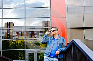 Portrait of a man in a sports suit, a jean jacket, a decorative T-shirt and jeans, a walk around the park and a commercial center photo