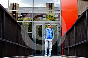 Portrait of a man in a sports suit, a jean jacket, a decorative T-shirt and jeans, a walk around the park and a commercial center photo