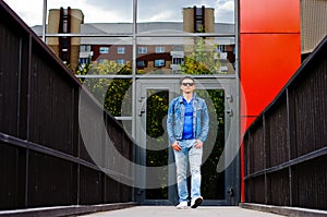 Portrait of a man in a sports suit, a jean jacket, a decorative T-shirt and jeans, a walk around the park and a commercial center photo