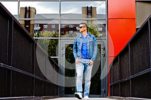 Portrait of a man in a sports suit, a jean jacket, a decorative T-shirt and jeans, a walk around the park and a commercial center photo