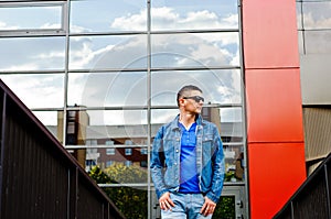 Portrait of a man in a sports suit, a jean jacket, a decorative T-shirt and jeans, a walk around the park and a commercial center photo