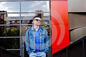 Portrait of a man in a sports suit, a jean jacket, a decorative T-shirt and jeans, a walk around the park and a commercial center photo