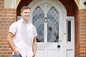 Portrait Of Man Standing Outside Front Door Of Home