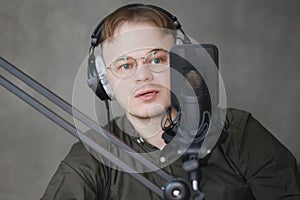 portrait of man in studio is recording podcast, audio content of interview on radio. Caucasian male