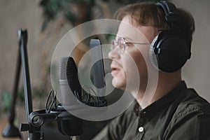 portrait of man in studio is recording podcast, audio content of interview on radio. Caucasian male