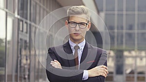 Portrait man in suit in front of office building. Handsome businessman outdoor. Male business person stands on street