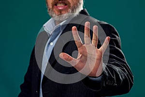 A portrait of man in suit showing stop gesture. Business and communications concept