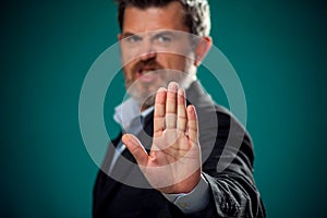 A portrait of man in suit showing stop gesture. Business and communications concept