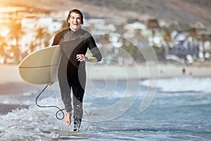 Portrait, man with surfboard and running on beach, happiness and summer vacation for weekend break. Surfer, male and