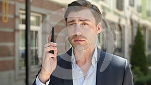 Portrait man talking on phone about work. Serious businessman calling partner