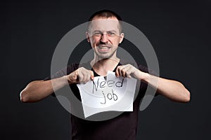 Portrait of a man tearing up an inscription on paper need a job