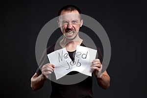 Portrait of a man tearing up an inscription on paper need a job