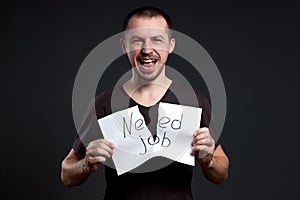 Portrait of a man tearing up an inscription on paper need a job