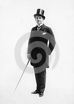 Portrait of a man in a top hat and morning suit holding a cane