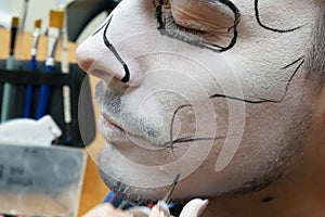 Portrait of man with traditional mexican halloween makeup, caballero celebrating day of the dead, face art, body art, closeup photo