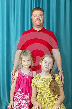 portrait of a man with two blonde daughters