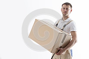 Portrait of man in uniform with cardboard box isolated on white background. Relocation service. Loader holds box