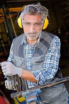 Portrait man using angle grinder