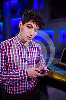 Portrait of man using mobile phone by bar counter