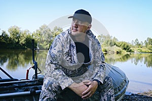 portrait of a man on vacation in nature, riding an airboat on the river in hunter's clothes