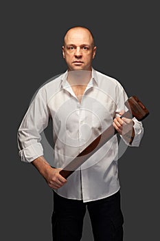 Portrait of a man in a white shirt with a hammer