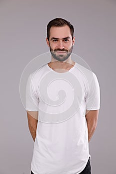 Portrait of a man in a white T-shirt on a gray background