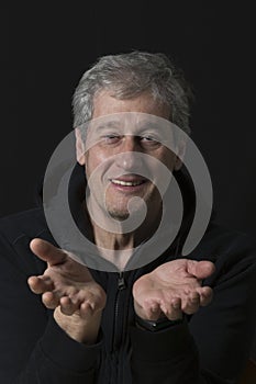 portrait of a man who has his hands extended in front as if showing them
