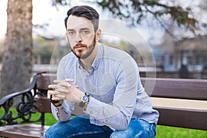 Portrait of a man who sits on a bench and thinks.