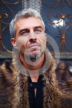 Portrait of a man in wolf fur and ornamental medieval window on background