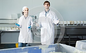 Portrait of man and woman dressed in lab coats are looking happy