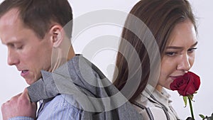 Portrait of man and woman having a quarrel close up. Couple standing with back to each other. Shooting in the studio on