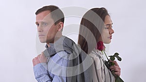 Portrait of man and woman sad close up. Couple standing with back to each other. Shooting in the studio on a white