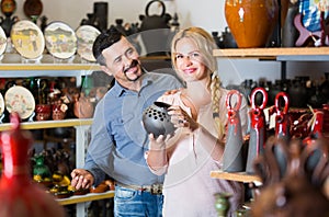 Portrait of man and woman shopping ceramic utensil in boutique